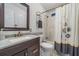 Bathroom with vanity, granite countertop, tile shower, and decorative mirror at 5733 Pawnee St, Zephyrhills, FL 33542