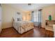 Comfortable bedroom with a queen bed, natural light and hardwood floors at 5733 Pawnee St, Zephyrhills, FL 33542