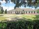 The community clubhouse has a welcoming facade with ample parking, featuring a brick base, trimmed windows, and a covered entrance at 5733 Pawnee St, Zephyrhills, FL 33542