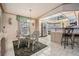 Well-lit dining area with a glass-top table sits adjacent to the kitchen at 5733 Pawnee St, Zephyrhills, FL 33542