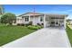 Charming single-story home features manicured lawn and an inviting front entrance with covered parking at 5733 Pawnee St, Zephyrhills, FL 33542