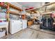 Functional garage with laundry area, workbench, and ample storage shelving offers both utility and organizational space at 5733 Pawnee St, Zephyrhills, FL 33542