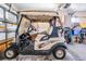 A golf cart awaits in this clean and organized garage, ready for leisure and convenience at 5733 Pawnee St, Zephyrhills, FL 33542
