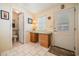 Bright hallway features a built-in desk, neutral tile floors, and a convenient bathroom access, alongside the exterior door at 5733 Pawnee St, Zephyrhills, FL 33542