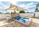 Outdoor hot tub covered with a sunshade umbrella with chairs around at 5733 Pawnee St, Zephyrhills, FL 33542