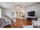 Inviting living room features hardwood floors, ceiling fan, and seamless flow into the adjacent kitchen at 5733 Pawnee St, Zephyrhills, FL 33542