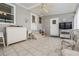 Covered patio featuring tile floors, white storage cabinet, seating area, and access doors at 5733 Pawnee St, Zephyrhills, FL 33542