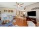 Living room with hardwood floors, neutral walls, and a view into the kitchen at 5733 Pawnee St, Zephyrhills, FL 33542