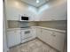 White kitchen with microwave, stove, and ample counter space at 1178 Green Oak Trl, Port Charlotte, FL 33948
