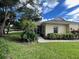 Cute yellow house with lush landscaping and walkway at 1178 Green Oak Trl, Port Charlotte, FL 33948