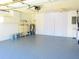 Garage with storage cabinets, shelving, and epoxy floor at 2501 Lonigan Pl, Sun City Center, FL 33573