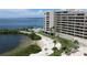 Aerial view of waterfront condo building with pool, beach access, and stunning bay views at 6009 Sea Ranch Dr # 705, Hudson, FL 34667