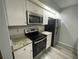 Modern kitchen with granite countertops, stainless steel appliances, and white cabinets at 14105 Mossy Glen Ln # 202, Tampa, FL 33613