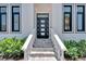 Modern entryway with gray tile steps and a dark door at 517 Treviso Dr, Apollo Beach, FL 33572