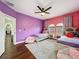 Bright bedroom with two twin beds and purple and pink walls at 3511 Loggerhead Way, Wesley Chapel, FL 33544