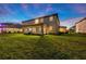 Expansive backyard featuring a covered patio, lush lawn and exterior view of the home at 33346 Kateland Dr, Wesley Chapel, FL 33545
