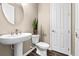 Powder room with pedestal sink, toilet and dark wood floors at 33346 Kateland Dr, Wesley Chapel, FL 33545
