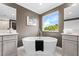 Bright bathroom showcasing a soaking tub, dual sinks, and a window with a scenic view at 33346 Kateland Dr, Wesley Chapel, FL 33545