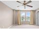 Bright bedroom with large windows, neutral colors, and a ceiling fan for comfortable living at 33346 Kateland Dr, Wesley Chapel, FL 33545