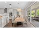 Open-concept dining area with designer light fixture, slider doors, and kitchen island at 33346 Kateland Dr, Wesley Chapel, FL 33545