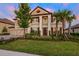 Stunning two-story home featuring meticulously landscaped front yard, paired with a three car garage and lush palm trees at 33346 Kateland Dr, Wesley Chapel, FL 33545