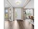 Inviting foyer with wood-look tile flooring, a white front door, and views into the dining and living areas at 33346 Kateland Dr, Wesley Chapel, FL 33545