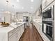 Spacious kitchen with stainless steel appliances, marble countertops, custom cabinets, and dark wood flooring at 33346 Kateland Dr, Wesley Chapel, FL 33545