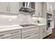 Modern kitchen featuring sleek white cabinets, stainless steel appliances, and a white subway tile backsplash at 33346 Kateland Dr, Wesley Chapel, FL 33545