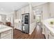 Kitchen features stainless steel refrigerator, custom cabinets, granite countertops, and hardwood floors at 33346 Kateland Dr, Wesley Chapel, FL 33545
