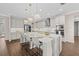 Bright kitchen with white cabinets, a large island with bar seating, and pendant lighting, and hardwood floors at 33346 Kateland Dr, Wesley Chapel, FL 33545
