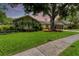 Beautiful home exterior, featuring a landscaped lawn and large tree at 4302 Deepwater Ln, Tampa, FL 33615