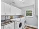 Clean laundry room with white cabinets, granite countertops, and a Samsung washer and dryer at 4302 Deepwater Ln, Tampa, FL 33615