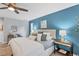 Main bedroom with king bed, blue accent wall, and pool view at 4302 Deepwater Ln, Tampa, FL 33615