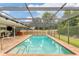 Refreshing screened pool with brick patio and a view of the backyard at 4302 Deepwater Ln, Tampa, FL 33615