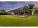 Screened-in pool and patio area surrounded by lush green lawn at 4302 Deepwater Ln, Tampa, FL 33615