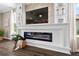 Modern fireplace with built-in shelving and a large TV above at 33346 Kateland Dr, Wesley Chapel, FL 33545