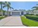 Single-story home with a two-car garage and lush landscaping at 812 Mccallister Ave, Sun City Center, FL 33573