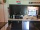 Retro kitchen with dark cabinets, white countertops, and stainless steel dishwasher at 10311 Us Highway 98, Dade City, FL 33525