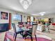 Elegant dining area with glass table, black chairs, and colorful rug at 17206 White Mangrove Dr, Wimauma, FL 33598