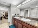 Double vanity bathroom with granite countertops and a view of the bedroom at 17206 White Mangrove Dr, Wimauma, FL 33598