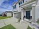 Two-story house front entry with gray columns, black door, and landscaping at 17206 White Mangrove Dr, Wimauma, FL 33598