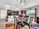 Modern dining area with glass table, black chairs, and kitchen view at 17206 White Mangrove Dr, Wimauma, FL 33598