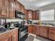 Well-equipped kitchen boasting dark wood cabinets and black appliances at 17206 White Mangrove Dr, Wimauma, FL 33598