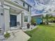 Two-story house front entry with gray columns, black door, and landscaping at 17206 White Mangrove Dr, Wimauma, FL 33598