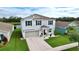 Two-story house with gray siding, gray garage door, and landscaping at 17206 White Mangrove Dr, Wimauma, FL 33598