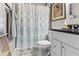 Updated bathroom with shower/tub combo, gray vanity, and patterned shower curtain at 2010 W Dekle Ave, Tampa, FL 33606