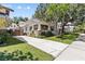 Exterior view of the home with a long driveway, mature trees, and a fenced yard at 2010 W Dekle Ave, Tampa, FL 33606