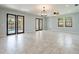 Spacious living room with tile floors, ceiling fan, and access to the pool at 7110 N Taliaferro Ave, Tampa, FL 33604