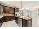 Island kitchen with granite countertops, stainless steel appliances, and dark wood cabinets at 7110 N Taliaferro Ave, Tampa, FL 33604