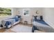 Guest bedroom with twin beds, blue bedding, and wood-look flooring at 5369 Tuscawilla Dr, Weeki Wachee, FL 34607